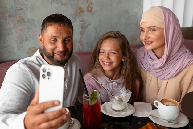 Free photo family taking selfie together while out at a restaurant