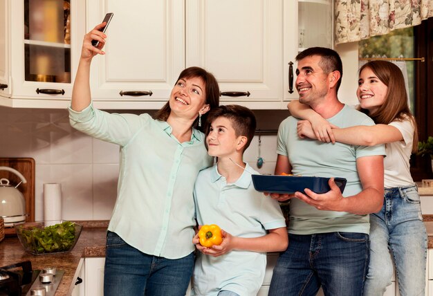 家族が夕食を準備しながら一緒にselfieを取る