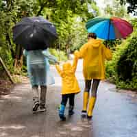 Free photo family taking a walk in the rain