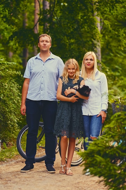 Foto gratuita una famiglia e il loro cane spitz in un parco.