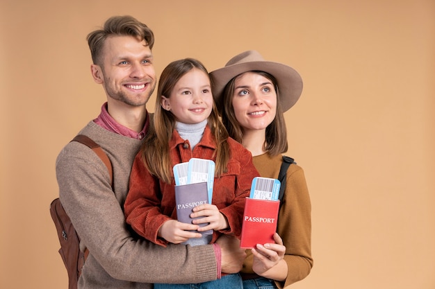 Foto gratuita famiglia di tre persone pronta per viaggiare con passaporto e biglietti aerei