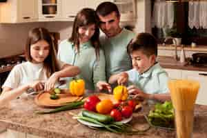 Foto gratuita famiglia che prepara insieme cibo in cucina