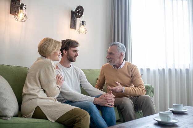 Family together. Son visiting his parents and talking to them