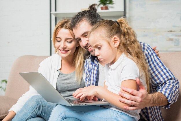 Family using the laptop on the sofa