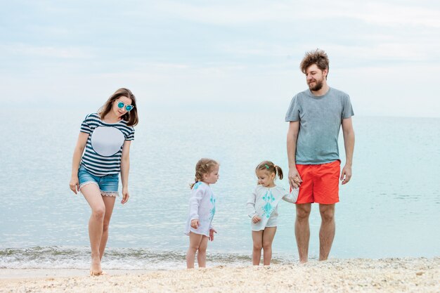 Семейный отдых родителей и детей на берегу моря летний день
