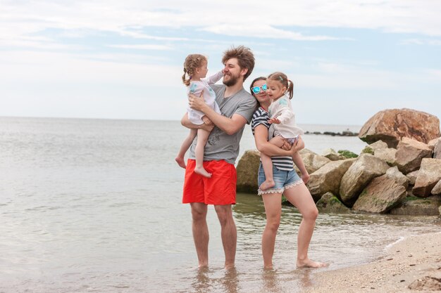 Family vacation parents and children on the sea shore summer day