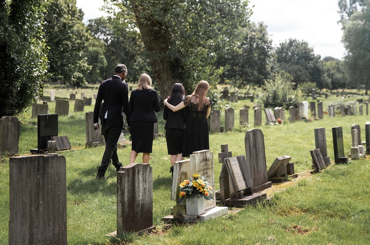 Free Photo family visiting grave of loved one
