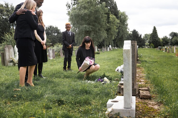 Free Photo family visiting grave of loved one