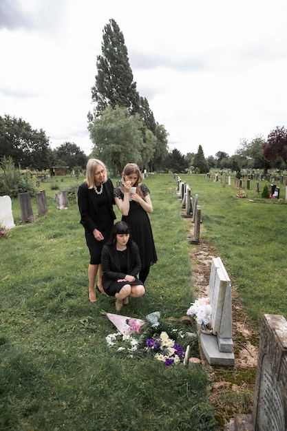 Free photo family visiting grave of loved one