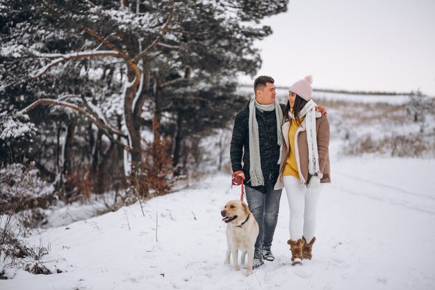 Family walking in winter park with their dog