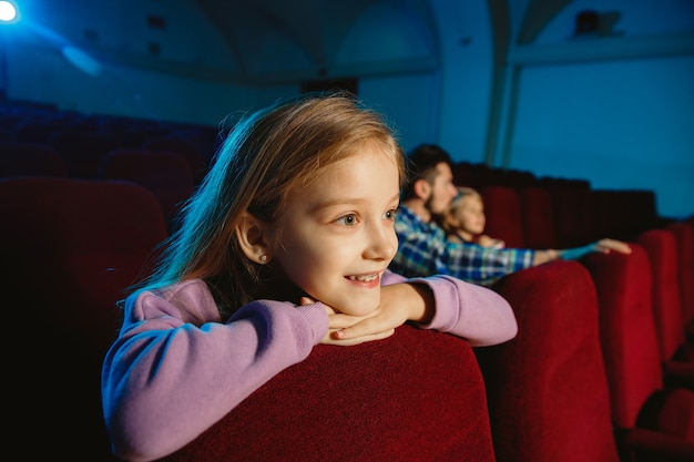 Family watching a film at a movie theater, house or cinema