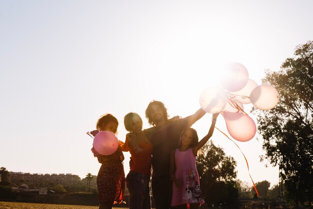 Семья размахивает руками с воздушными шарами