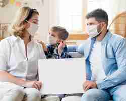 Free photo family wearing medical masks indoors copy space