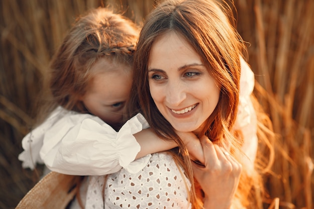 Free photo family in a wheat field. woman in a white dress. girl with straw hat.