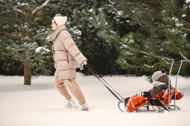 Family in winter clothes on vacation in snowy forest