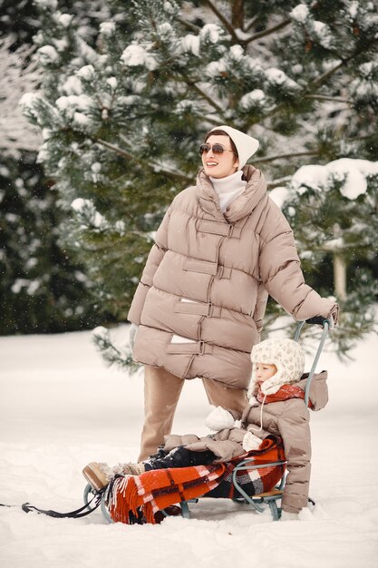 雪の森で休暇中の冬服の家族