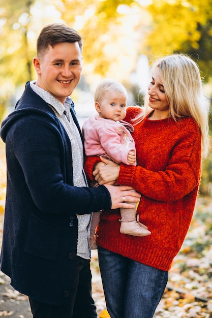 Free photo family with baby daugher walking in an autumn park