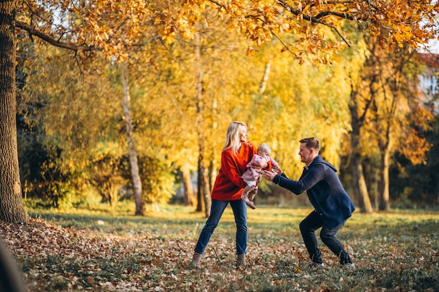 Family with baby daughter walking in an autumn park