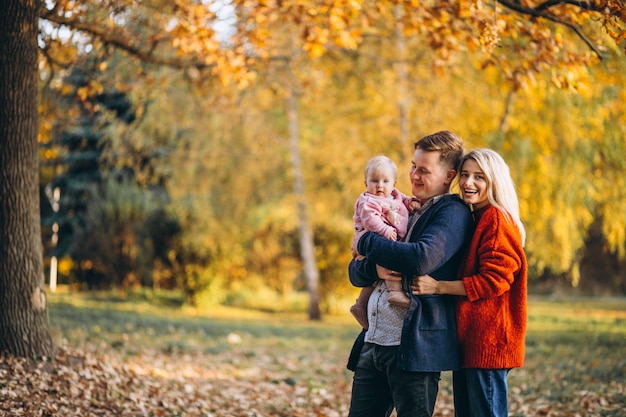 Family with baby daughter walking in an autumn park