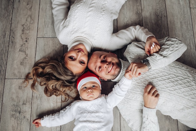 Family with baby Santa in hat.