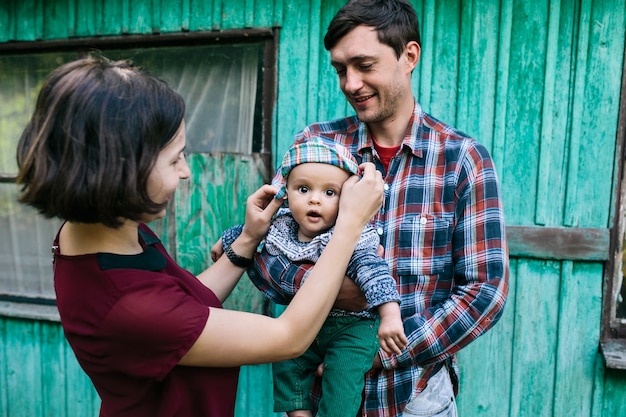 Free photo family with baby standing outside of house