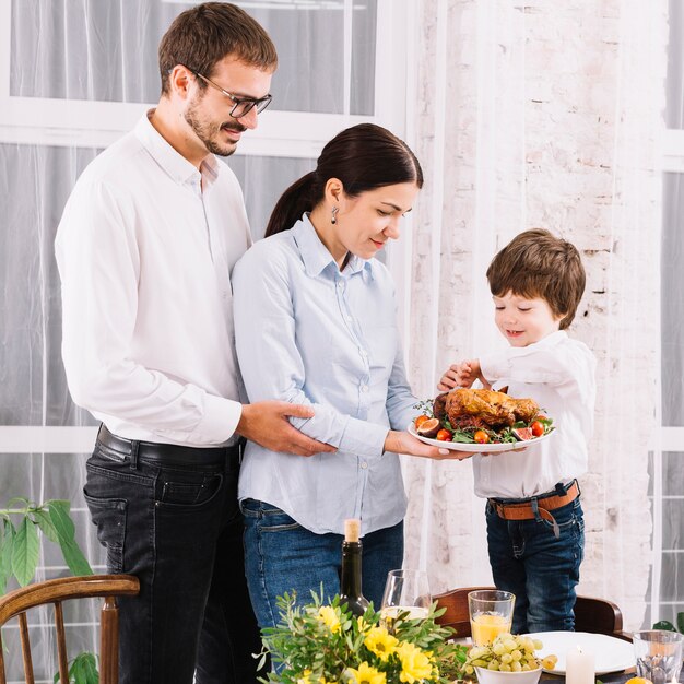 Family with baked chicken at table 