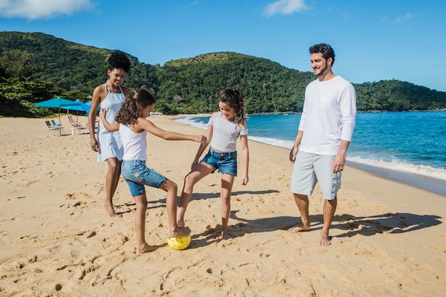 Семья с мячом на пляже