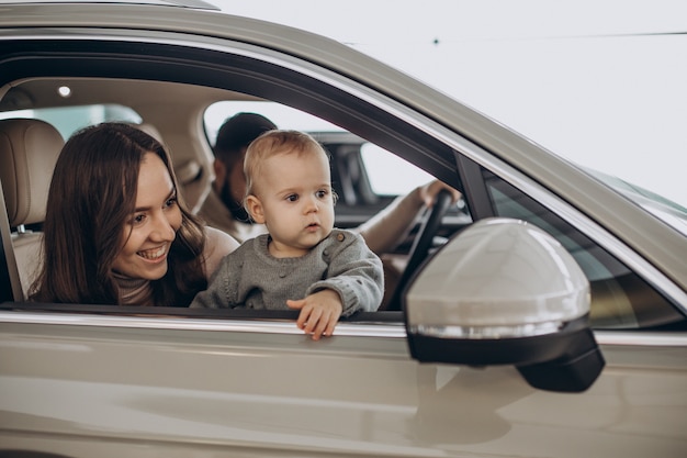 Family with bbay girl choosing a car in a car saloon