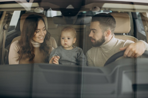 Family with bbay girl choosing a car in a car saloon