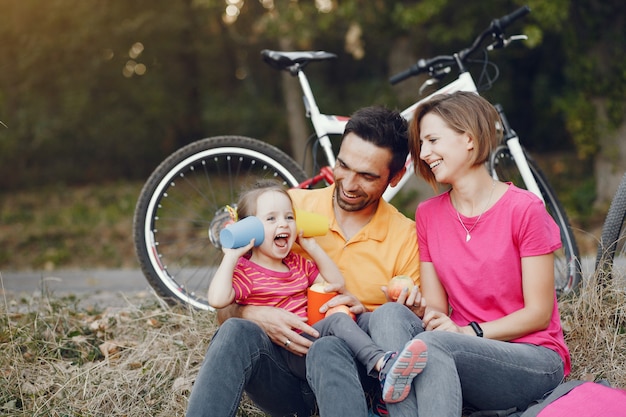 Foto gratuita famiglia con una bicicletta in un parco estivo