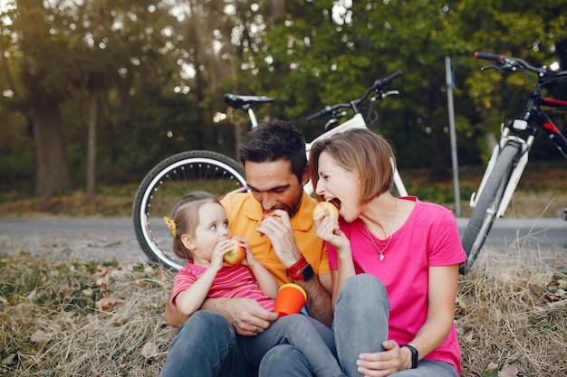 Foto gratuita famiglia con una bicicletta in un parco estivo