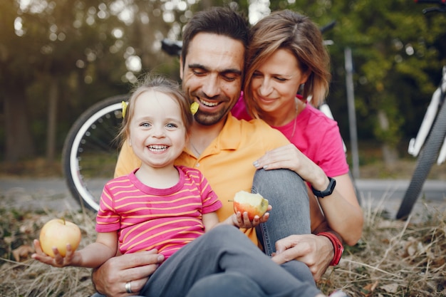 Free photo family with a bicycle in a summer park