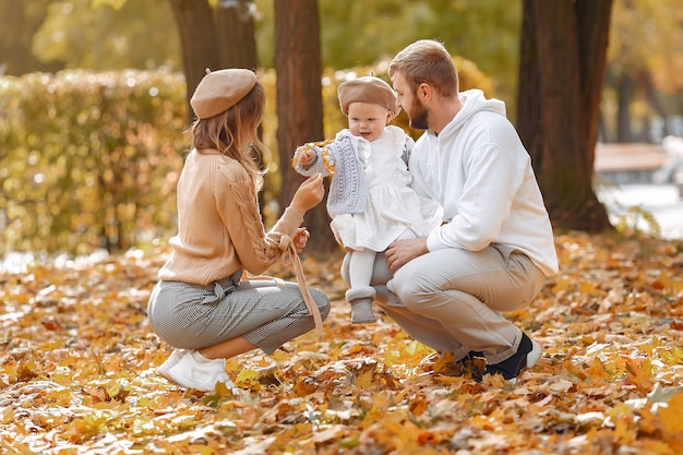 秋の公園で小さな娘と家族