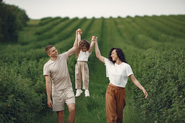 Free photo family with little daughter spending time together in sunny field