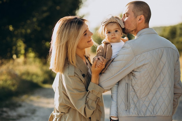 Family with little daughter spending time together in sunny field