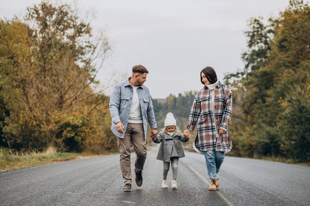 Family with little daughter together in autumnal weather having fun