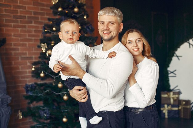 Family with little son at home near christmas tree