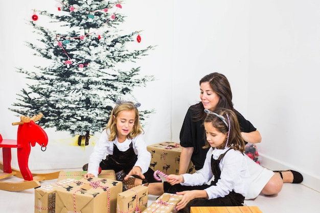 Family with present boxes and christmas tree