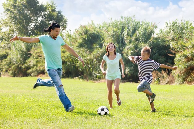 Семья с подростком, играющим в футбол