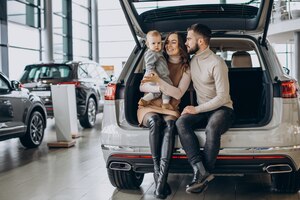 family with toddler girl choosing a car in a car showroom
