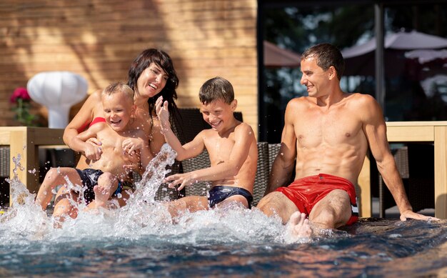 두 아이가 수영장에서 하루를 즐기고있는 가족