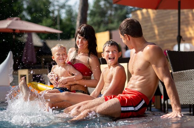 두 아이가 수영장에서 하루를 즐기고있는 가족