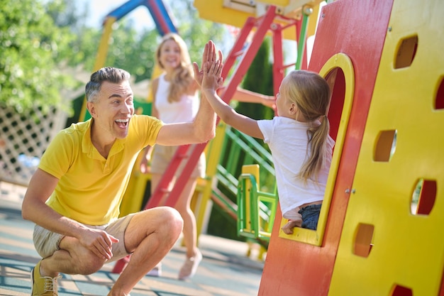 La famiglia gioca al parco giochi e si sente divertita