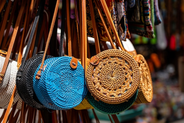 인도네시아 발리 우붓의 거리에 있는 현지 기념품 시장에서 유명한 발리 등나무 에코백. 수공예품 및 기념품 가게 디스플레이, 클로즈업