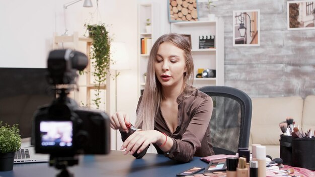 Famous beauty vlogger picking up a brush for makeup and using it to demostrate a make up