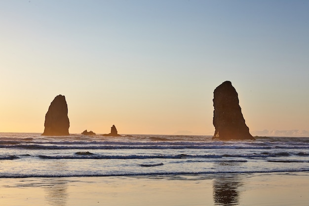 Famous Haystack Rock on the rocky shoreline of the Pacific Ocean