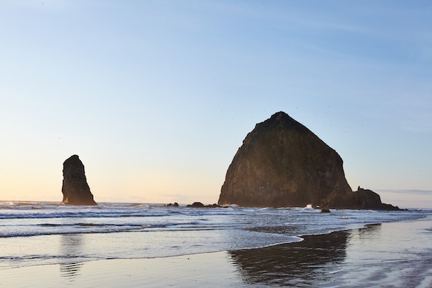 Famous Haystack Rock on the rocky shoreline of the Pacific Ocean