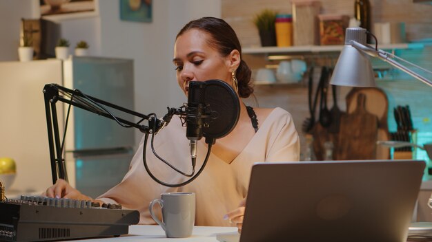 Famous woman holding professional microphone while recording podcast for social media. On-air online production internet broadcast show host streaming live content, recording digital social media comm