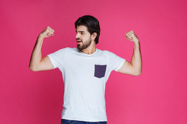 A fan showing his fist and muscles as his team won. 