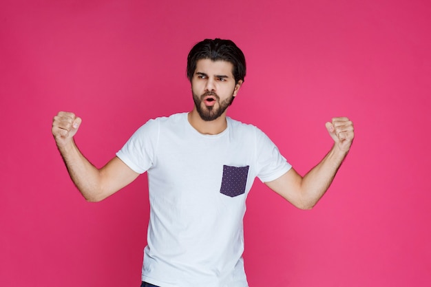 A fan showing his fist and muscles as his team won. 